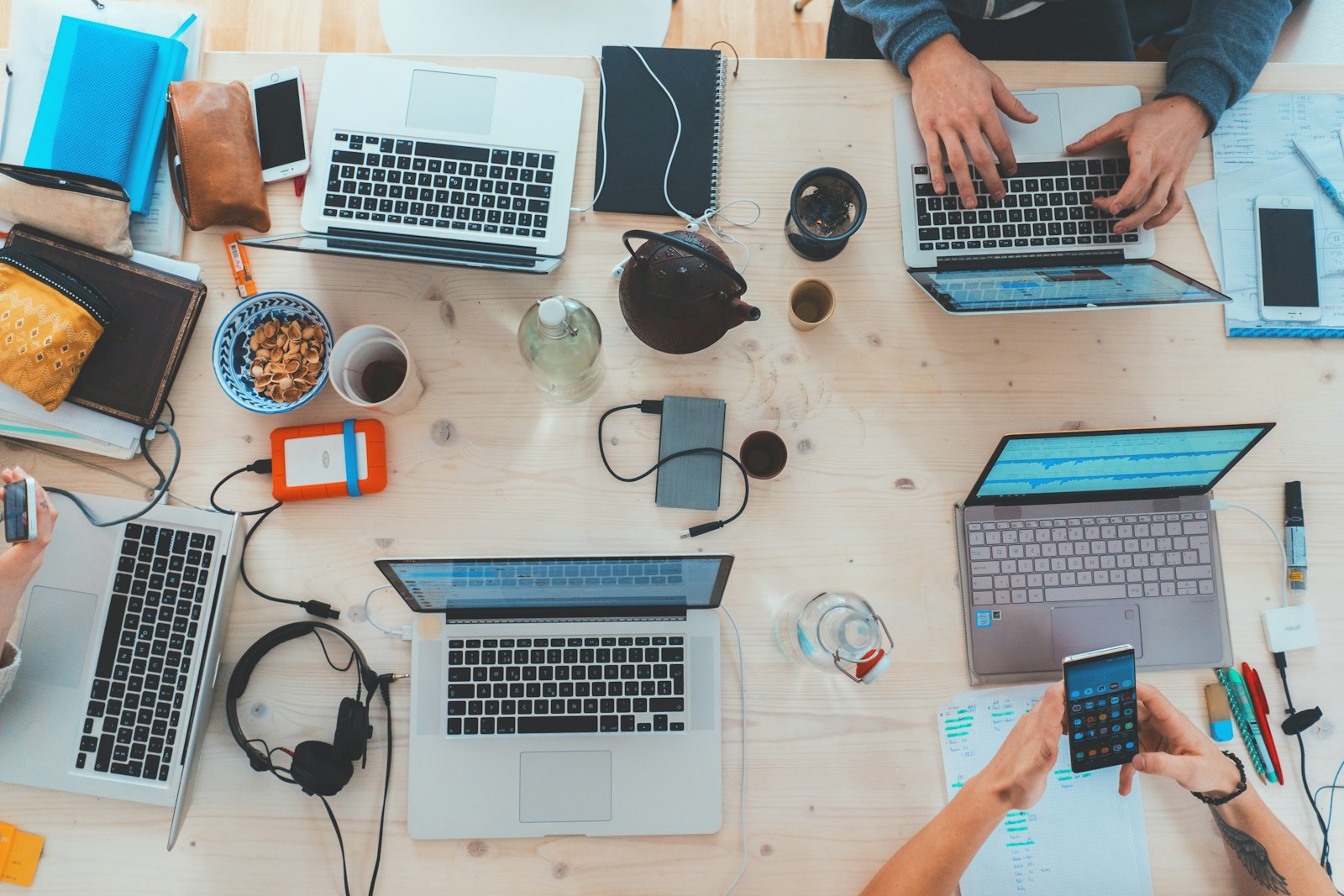 Estudiantes colaborando con computadoras portatiles.